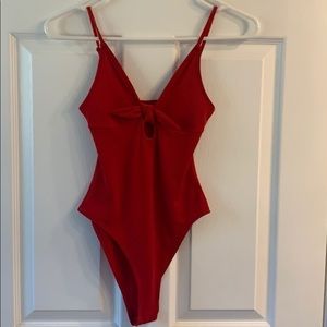 red body suit with a cut out and a bow
